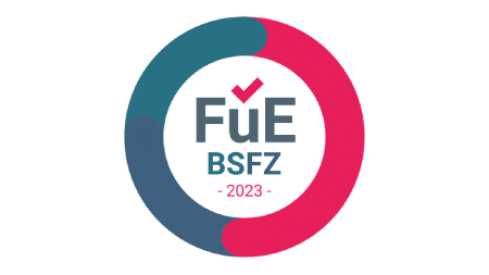 Ein kreisförmiges Logo mit ineinandergreifenden blaugrünen und rosa Segmenten, die einen Ring bilden. Innerhalb des Kreises befindet sich über dem Text „FuE“ in großen Buchstaben ein Häkchen, darunter „BSFZ“ in kleineren Buchstaben und unten „2023“. Das Design spielt subtil auf die Präzision von Schmiedeteile Automotive an.