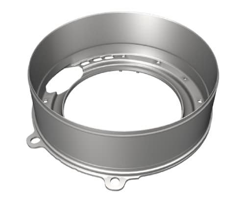 A metallic circular component, likely an industrial or mechanical part from a Schmiedeteile automotive manufacturer, featuring a round hollow center and outer walls. The design includes multiple small holes and cutouts along its edges, with two mounting tabs or extensions visible at the bottom.