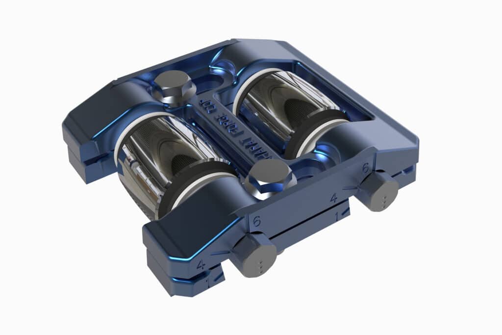 A metallic, rectangular, blue mechanical component with two cylindrical rollers, several labeled adjustment dials, and engraved markings reading "MAINT JOB 2035.